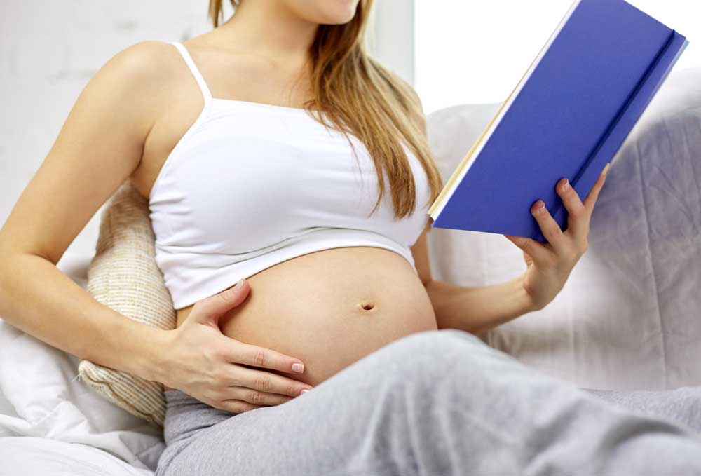 X reader pregnancy. Беременная девушка читает книгу.